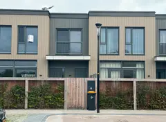 Rijwoning met verticale gevel van composietpanelen.