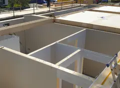 Bovenaanzicht van montage van een vloer met houten balken en constructieplaten.