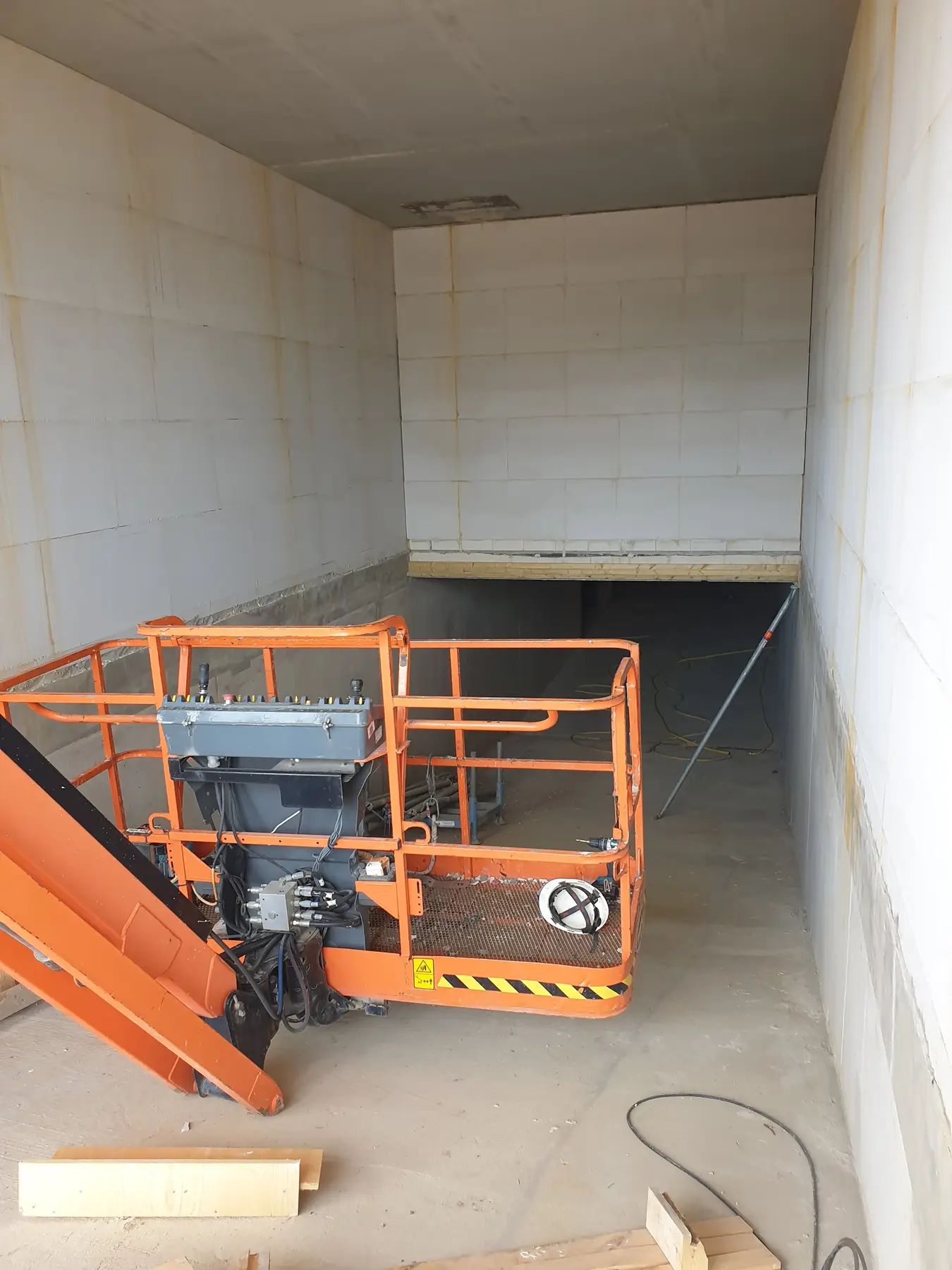 Ruimte in ruwbouwfase met bouwlift.