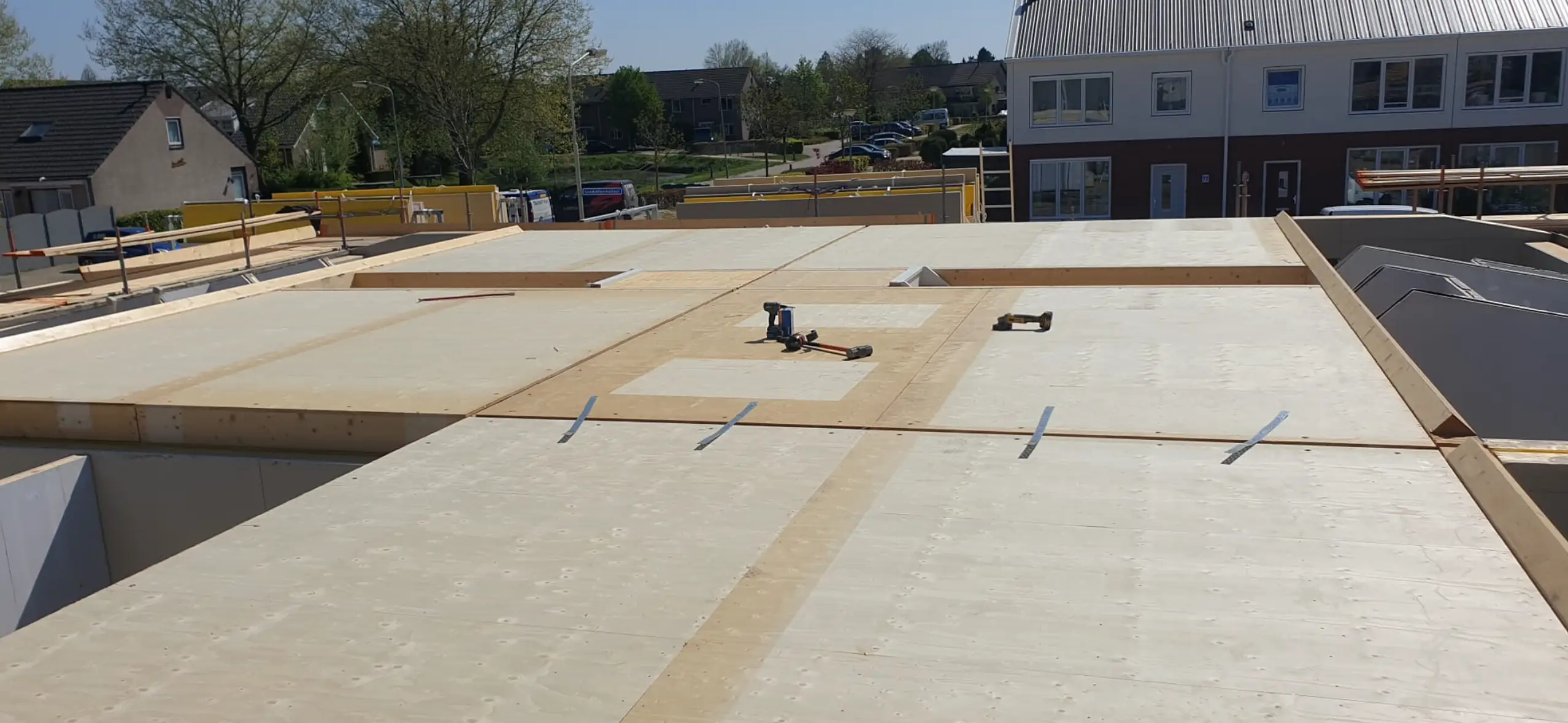 Houten vloer met gemonteerde platen en gereedschap op het oppervlak.